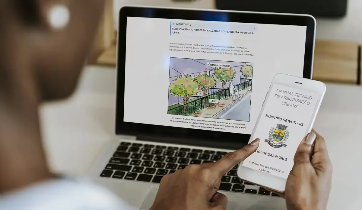Pessoa interagindo com documentos sobre plantio de árvores em calçadas, com informações visíveis em computador e smartphone.